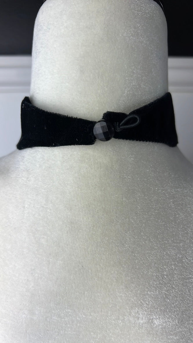 Black Eretica choker with pearlescent button and skull and crossbones detail